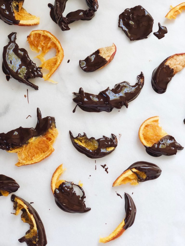 Kinderen maken gedroogde sinaasappelschijfjes met chocolade